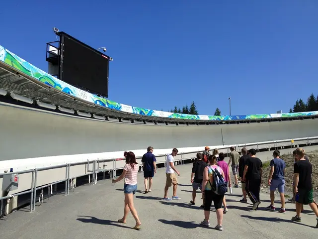 There are group of people walking. I think this is the grass. This looks like a scoreboard. These...